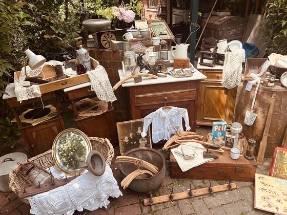 Sommerlicher Hofverkauf mit Waschtischen, Körben, Bilderbüchern und Kinderkleid