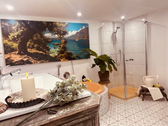Badezimmer mit Wanne, Dusche, Wandbild und Kerzendeko
