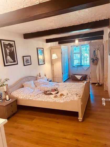 Gästezimmer mit Landhausbett, Kleiderschrank und Deckenbalken